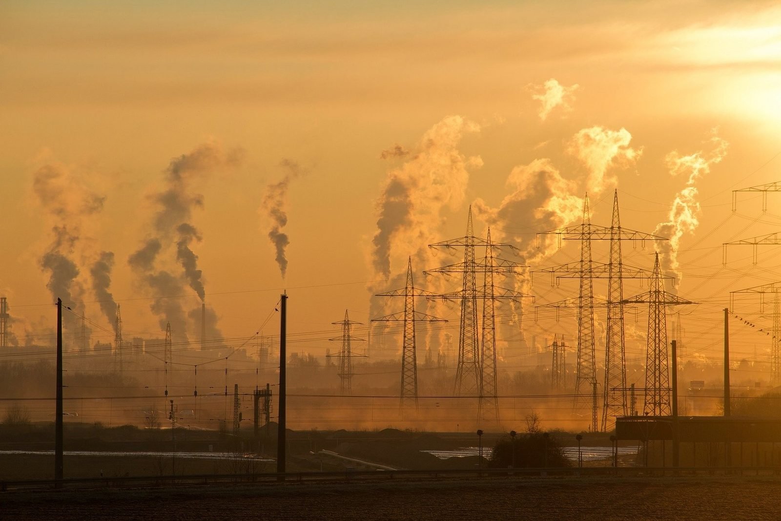 Chaminés industriais emitindo plumas ao entardecer