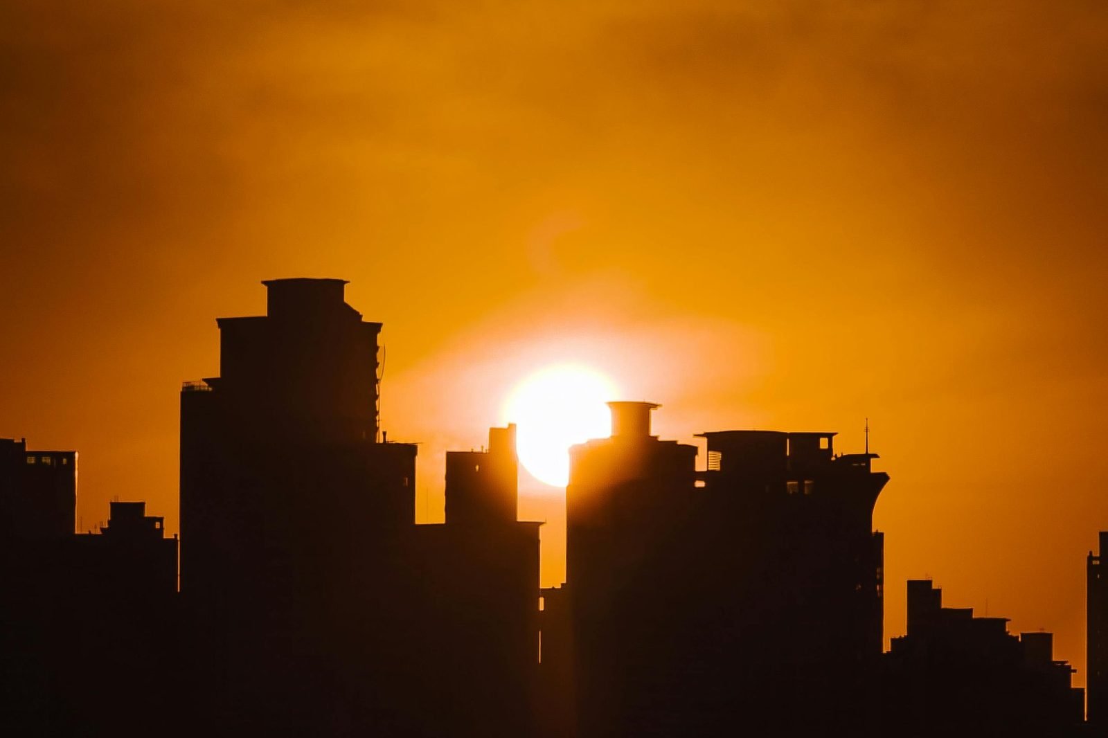 Silhueta de prédios contra o pôr do sol em cidade