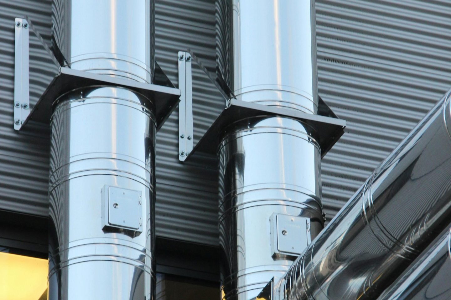 Dutos de exaustão metálicos em fachada industrial