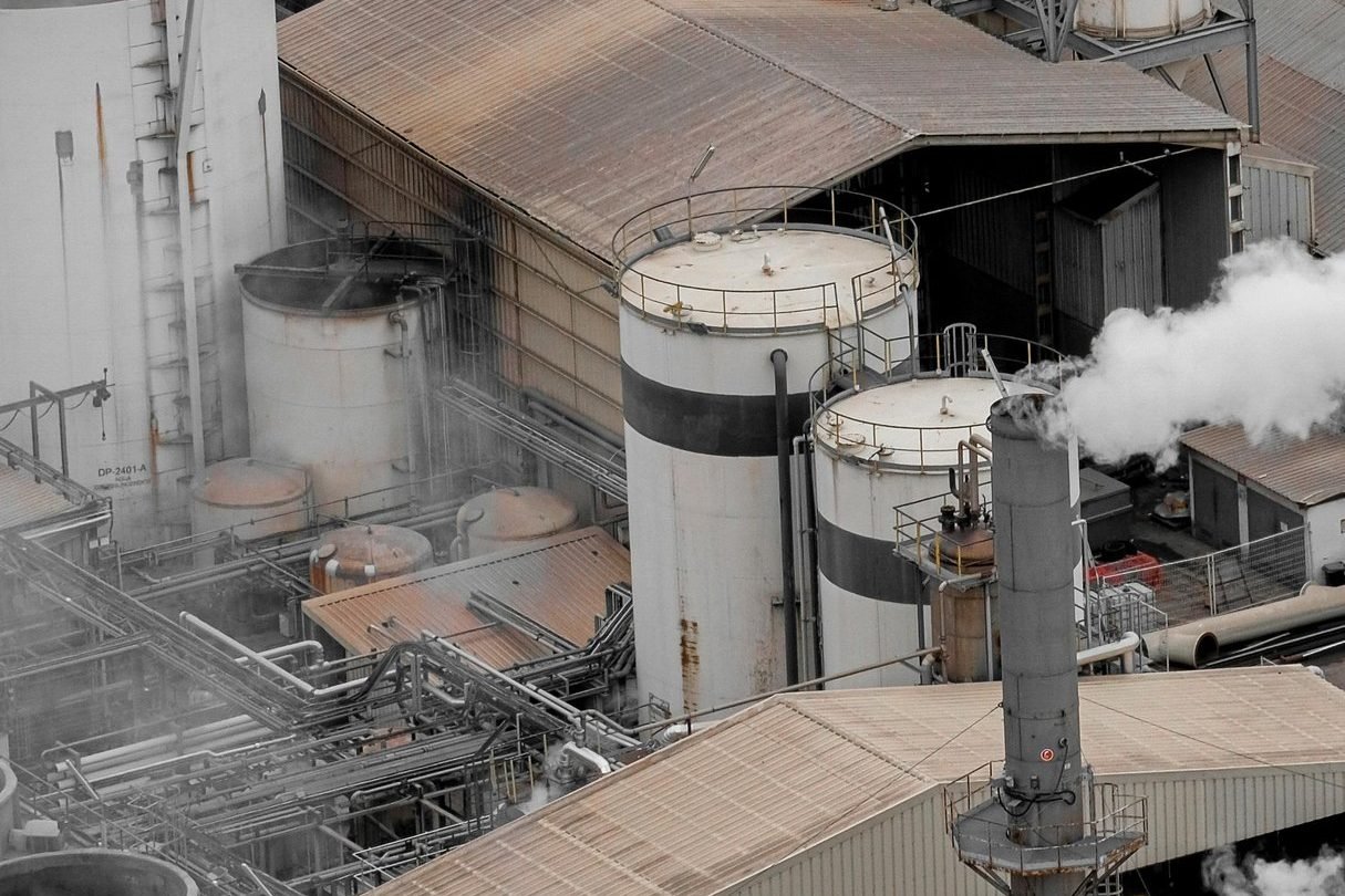 Vista aérea de instalação industrial com tanques e chaminé